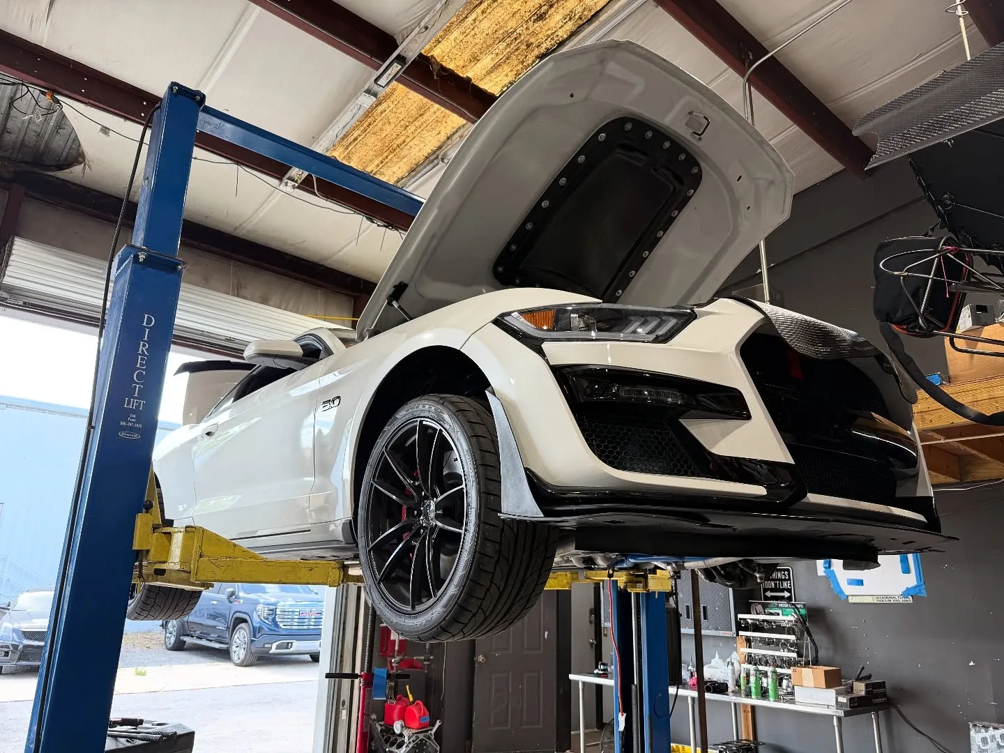 A white GT500 nose up on the lift for a custom twin turbo build