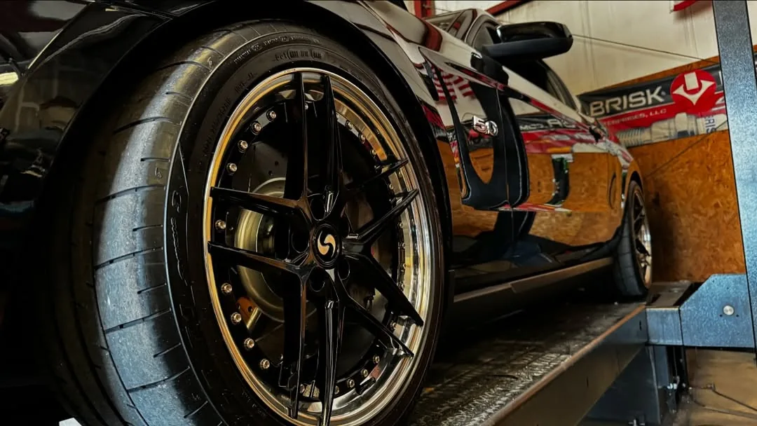A Mustang's rear wheel strapped down on the DynoJet rollers