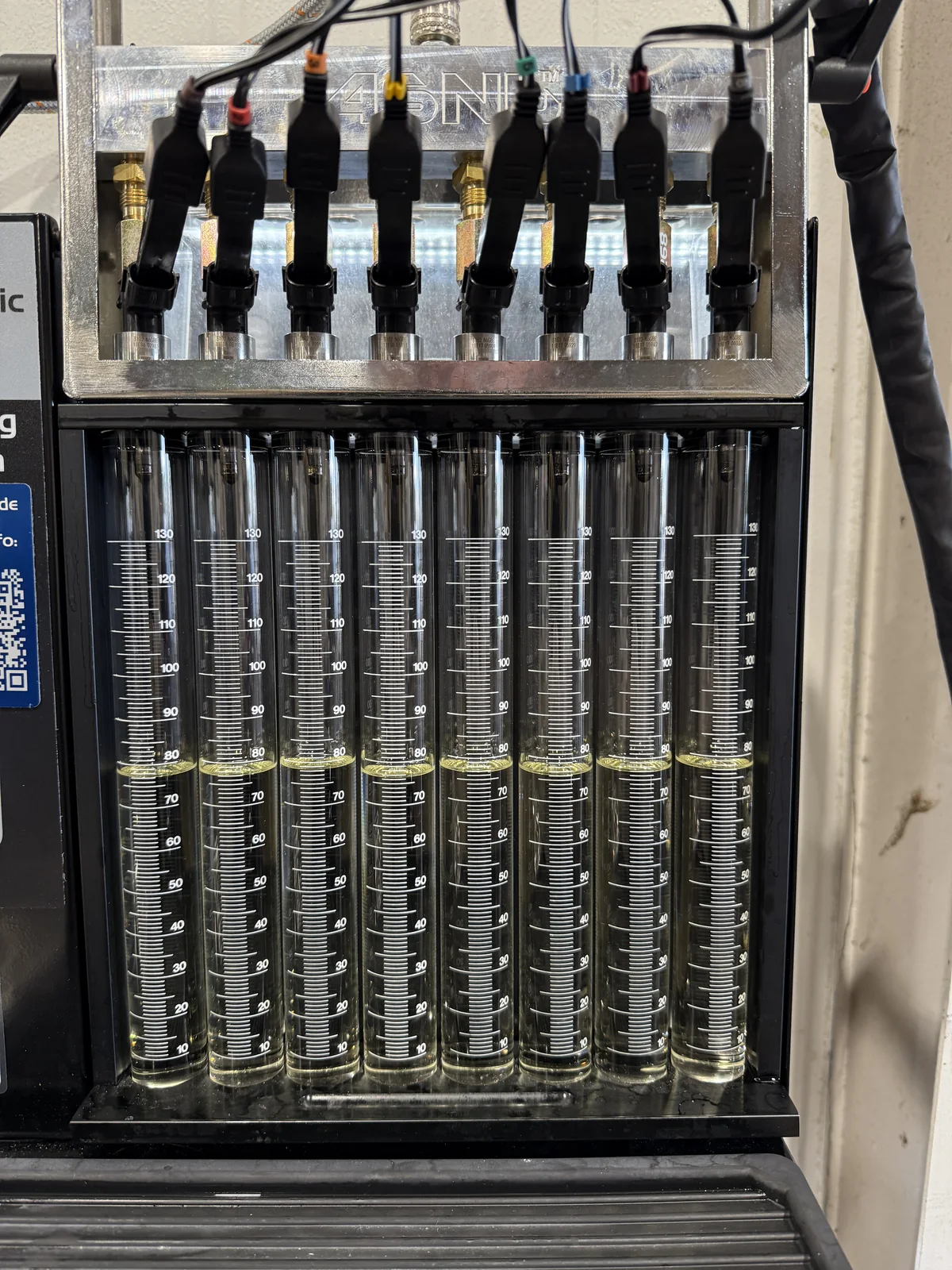 A set of eight injectors mounted on the ASNU rack, firing into the graduated tubes below