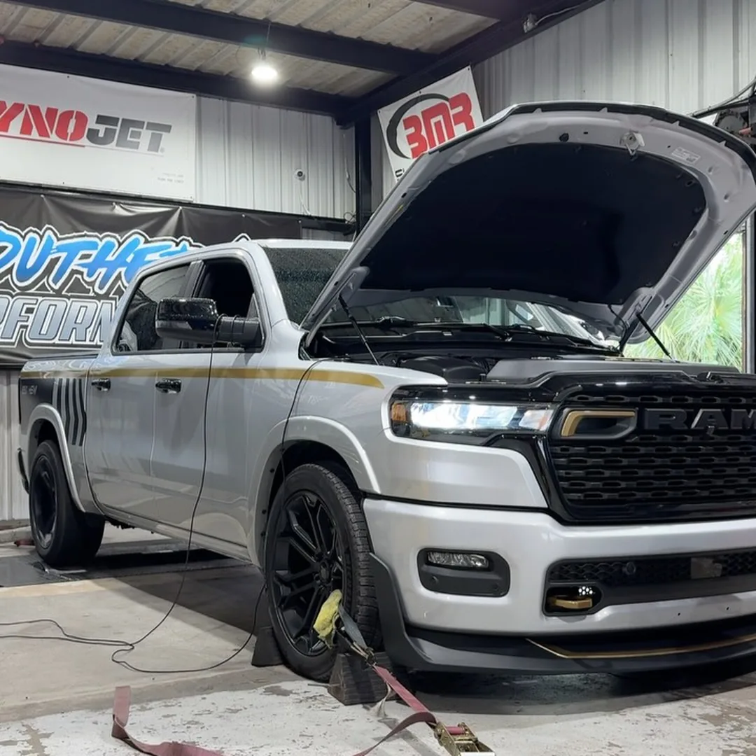 A silver Ram 1500 pickup with its hood open in the dyno bay, with Dynojet and Southern Performance banners on the wall behind it.